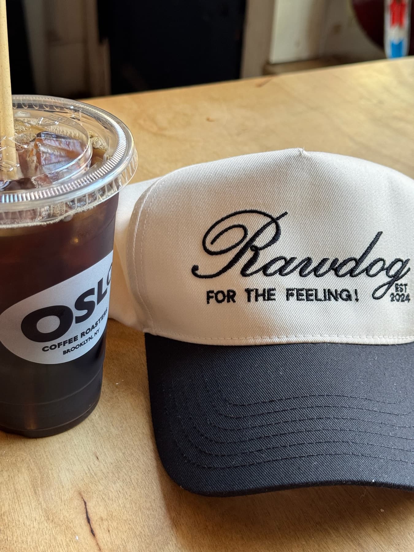 RAWDOG Trucker Hat next to an iced coffee